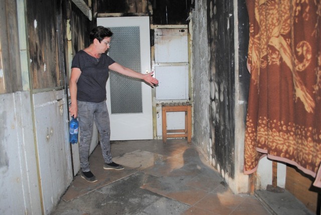 Pani Maria pokazuje, gdzie w korytarzu powstał ogień, który rodzinie odciął drogę ucieczki