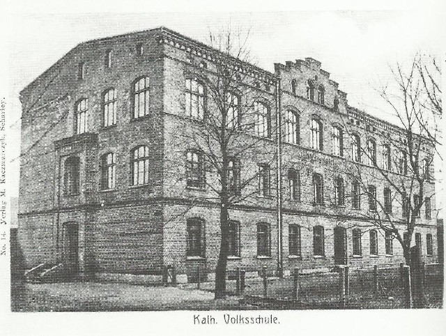 Katolicka szkoła ludowa nr 1 zbudowana dla dzieci z gminy Szarlej w 1870 r. (obecnie Urząd Miejski). Pocztówka z ok. 1905 r.
