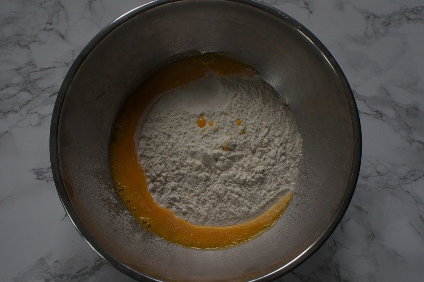 Rozkłócone jajko należy wlać do mąki pszennej z drożdżami.
