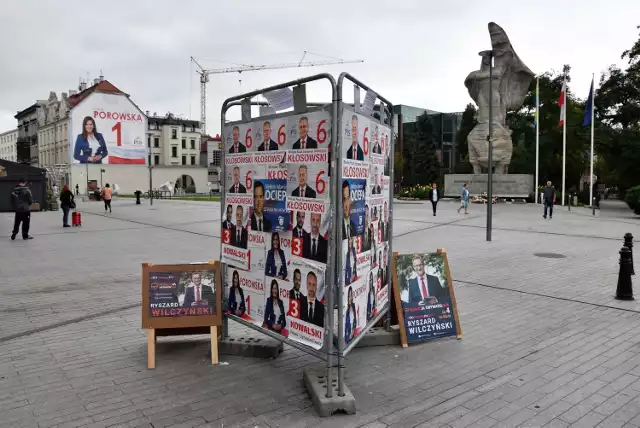 Kandydaci PiS zaklejają się nawzajem na stojaku na ul. Krakowskiej. Ryszard Wilczyński z KO wystawił swoje "potykacze" obok. MZD informuje, że bez pozwolenia.