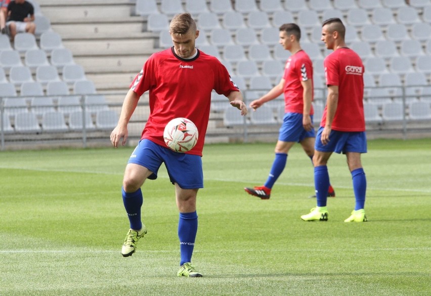 Zawodnik Granatu Skarżysko-Kamienna, Tomasz Bartosiak, biega za piłką i z pizzą 