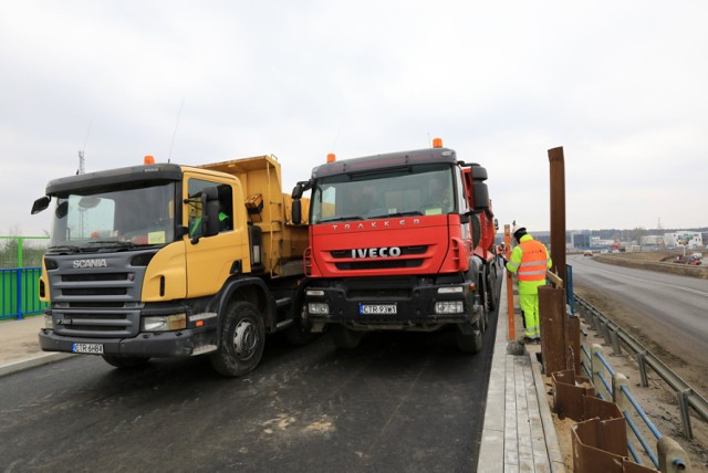 Nowy wiadukt przy przebudowywanej ulicy Łódzkiej w Toruniu przechodził ostatnio próbę obciążeniową. Przypomnijmy, że w ramach inwestycji powstają dwa takie obiekty nad torami kolejowymi. Każdy z nich będzie miał długość prawie 38 m. Pierwszy z nich, tzw. południowo-zachodni, będzie miał szerokość 9 m, a drugi - po stronie północno-wschodniej - 12,7m. Do ich wybudowania zostanie zużyte 1200 m sześc. betonu i 110 ton stali. Na szerszym wiadukcie oprócz ruchu pojazdów zostanie wytyczony ciąg pieszo-rowerowy, na węższym będzie dopuszczony tylko ruch kołowy. Przebudowa Łódzkiej zakończy się 21 października. Inwestycja kosztuje 16,8 mln zł., z czego 85% zostanie pokryte ze środków unijnych.

Zobacz także: Copernicus Cup - znowu komplet kibiców na trybunach. Byłeś? Zobacz, czy jesteś na zdjęciu! [GALERIA, FOTORELACJA]

Próba obciążeniowa na wiadukcie na ulicy Łódzkiej w Toruniu [GALERIA ZDJĘĆ] Nowa konstrukcja przeszła testy wytrzymałośc