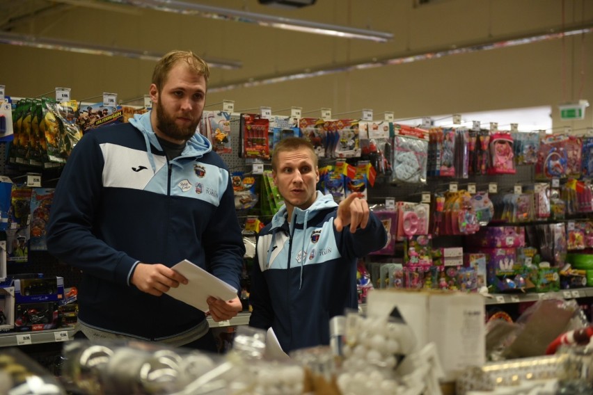 Toruńscy koszykarze wrzucają prezenty do Szlachetnej Paczki...