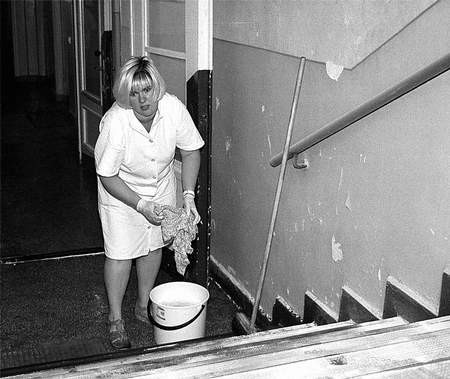 Hanna Ziętek zmywa ze schodów szpitalnego korytarza, proszek z gaśnicy.
Fot. Aleksander Winter