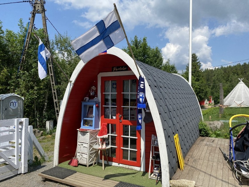 Malutki czerwony domek i fińskie flagi. Kawałek północnej...