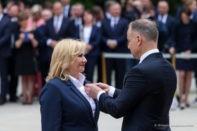 Prezydent Andrzej Duda odznacza Iwonę Koperską, przewodnicząca Sejmiku Województwa Łódzkiego. Na kolejnych zdjęciach inni odznaczeni.