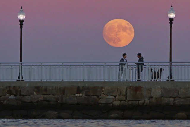 People watch the moonrise from the pier at fort taber park in the south end of new bedford, mass., sunday, nov. 23, 2016. (peter pereira/standard times via ap)