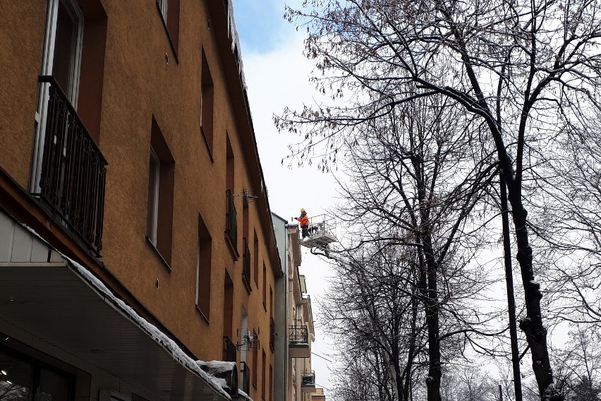 Służby porządkowe usuwają zalegający na dachach śnieg oraz...