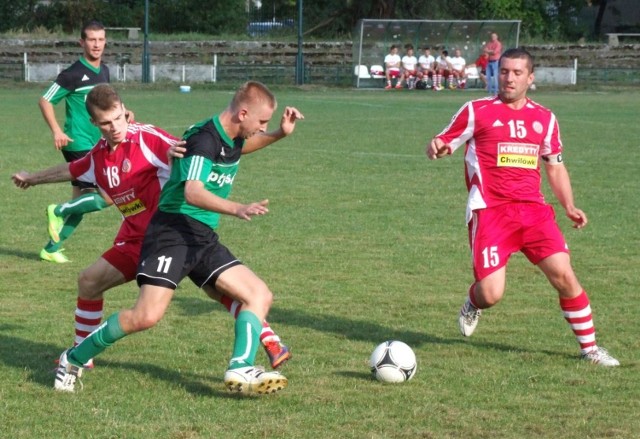 Bartłomiej Mika (zielona koszulka, nr 11), autor gola dla Chełmka, w pojedynku z Szymonem Brańką (Soła II). Z boku Krzysztof Zarzycki (Soła II), a w tyle Sebastian Chojnowski (Chełmek).