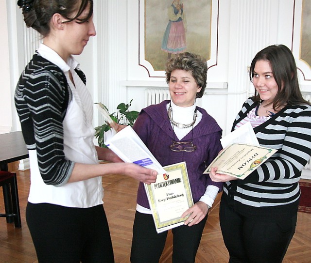 Karolina Maślanka (z lewej) i Magdalena Zawalska pokazują nagrody opiekunce Ewie Perlińskiej (w środku)