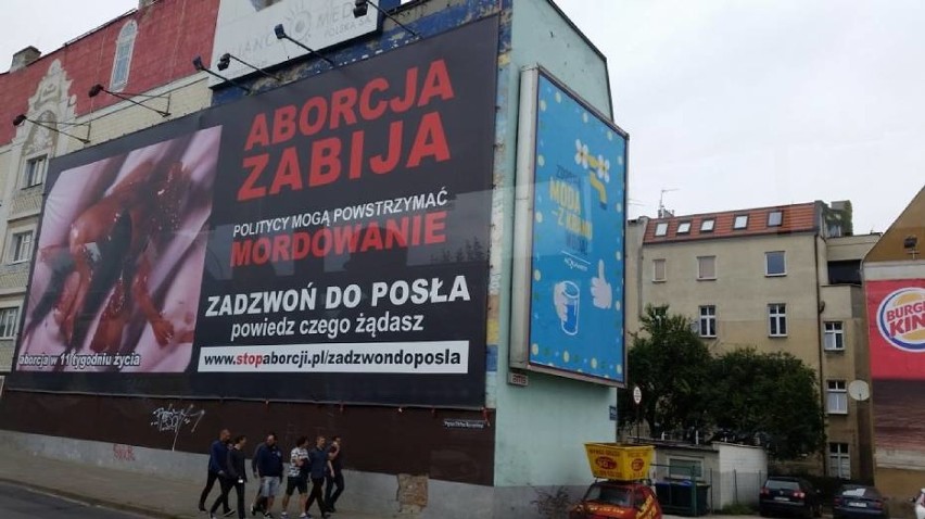 Na ogromnym bilbordzie możemy zobaczyć zmasakrowany ludzki...