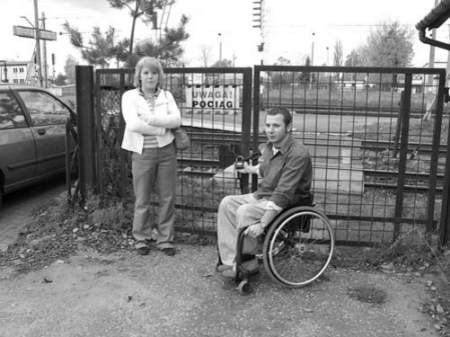 Katarzyna Osajda i Tomasz Boruciński przed zamknietą na klucz bramką. Jest to jedyne możliwe przejście na peron dla niepełnosprawnych.