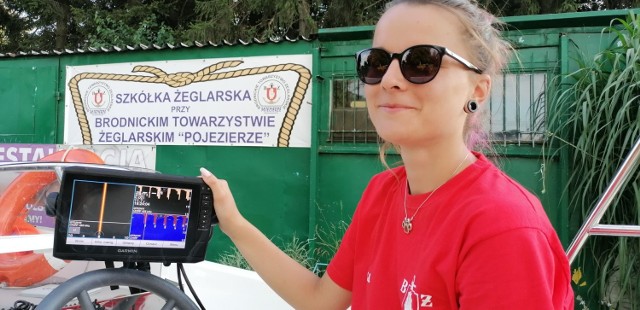 Aleksandra Barańska, kierowniczka oddziału WOPR Toruń przy Brodnickim Towarzystwie Żeglarskim prezentuje na monitorze obraz powstały przy użyciu sonara. Widoczne mogą być zatopione konary, dawny pomost czy nawet wodorosty unoszące się w toni