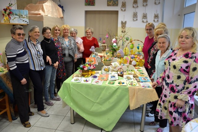 Uczestnicy Dziennego Domu Senior+ przy wystawie wykonanych przez siebie prac wielkanocnych