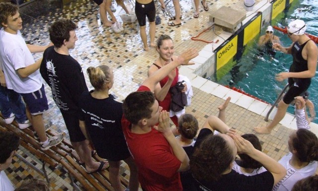 Kamila Kunka (w czerwonym stroju) przyjmująca gratulacje od kolegów za życiowy wynik w pływackim Grand Prix Małopolski, rozegranym w Krakowie.