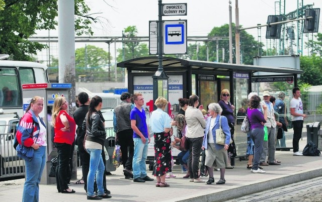 Ludzie na przystanku przy Dworcu Głównym PKP muszą stać, czekając na autobus linii nr 715