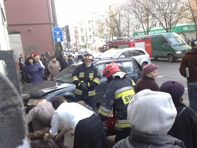 Rozbity samochód blokuje przejście przy urzędzie, tramwaj z rozrytym przodem blokuje torowisko... Ratownicy pomagają ofierze wypadku.