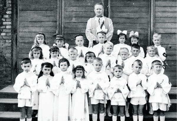 Dzieci  wczesnokomunijne z ks. proboszczem Józefem Olesiem. Gabriela Górska druga z lewej w 2. rzędzie