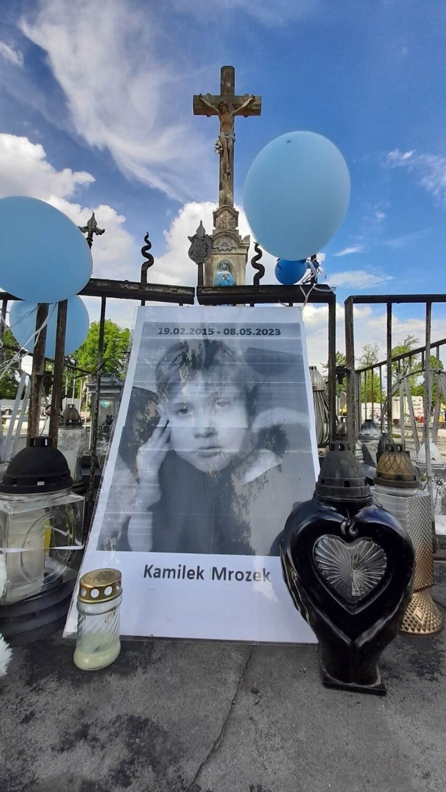 Mieszkańcy Rydułtów zapalają znicze pod krzyżem na cmentarzu parafii św. Jerzego, gdzie ktoś położył fotografię Kamilka