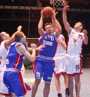 Grający trener Sportowca Dariusz Szynkiel (z piłką) mimo obrony Łukasza Wójcika atakuje kosz MMKS Dąbrowa Górn.