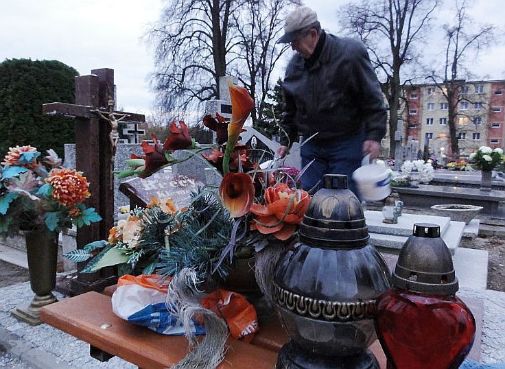 Tadeusz Recki sprząta grób bliskich na cmentarzu w Sławnie