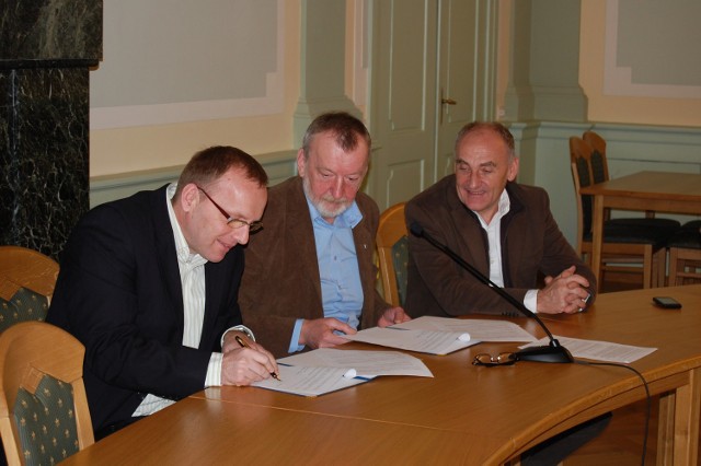 Janusz Świder podpisuje umowę czemu bacznie przyglądają się burmistrz Andrzej Krzysztofiak i Czesław Lang