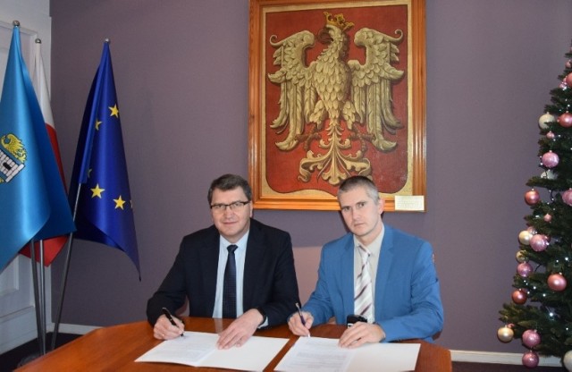 Janusz Chwierut (z lewej), prezydent Oświęcimia, podpisuje dokument o przekazaniu nagrody finansowej dla hokeistów Re-Plast Unii Oświęcim z Pawłem Kramem, szefem spółki Oświęcimski Sport