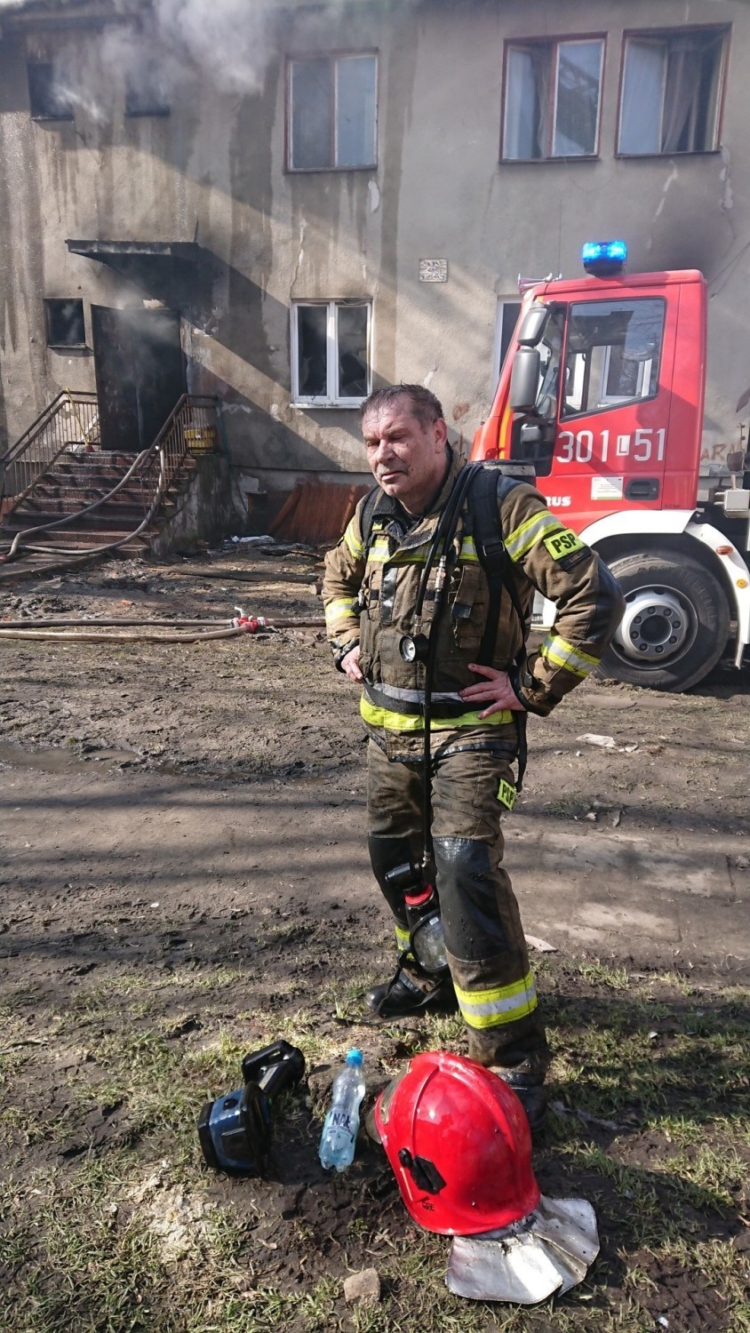 Asp. sztab. Piotr Gryta podczas gaszenia pożaru w bloku przy...