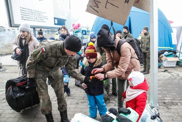 Żołnierze i wolontariusze pomagają uchodźcom na przejściu granicznym w Medyce