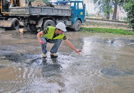 Paweł Jędrzejczak pokazuje miejsce, gdzie woda wybiła spod asfaltu.