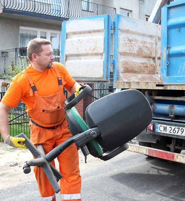 Artur Redliński pakuje wystawiony, niepotrzebny już fotel.