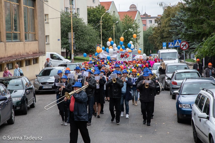 Seniorzy w barwnym korowodzie, prowadzeni przez orkiestrę...