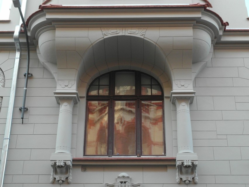 Okno otoczone kolumnami przechodzącymi w okazały wykusz