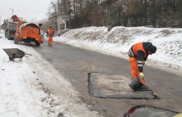 Na ulicy Cedzyńskiej  mimo śniegu i mrozu są łatane dziury. W konewce przenoszona jest smoła, która służy do uszczelniania łat.