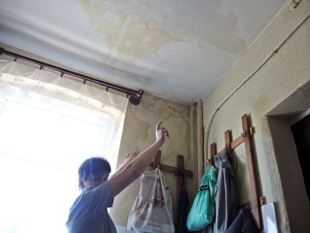 Pani Anna pokazuje zalany sufit i ściany w kuchni. - Wolałabym, żeby TBS to zamalował, ale chcą żebym to zrobiła sama, a oni dadzą pieniądze na remont - mówi.