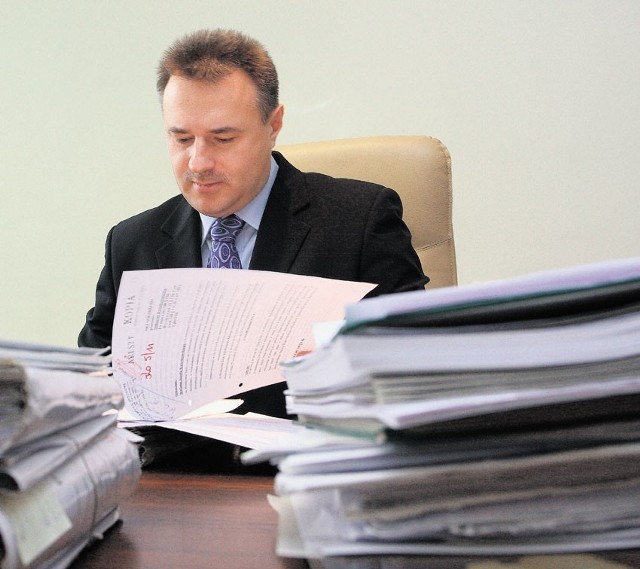 Prokurator Witold Błaszczyk ma na biurku stosy akt