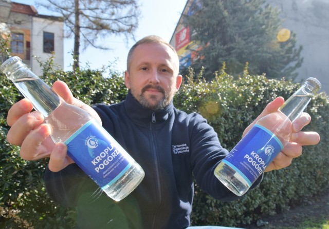 Jan Czaja z TOT z pierwszymi butelkami Kropli Pogórza. Na etykietach umieszczone jest m.in. logo Źródlanego Szlaku