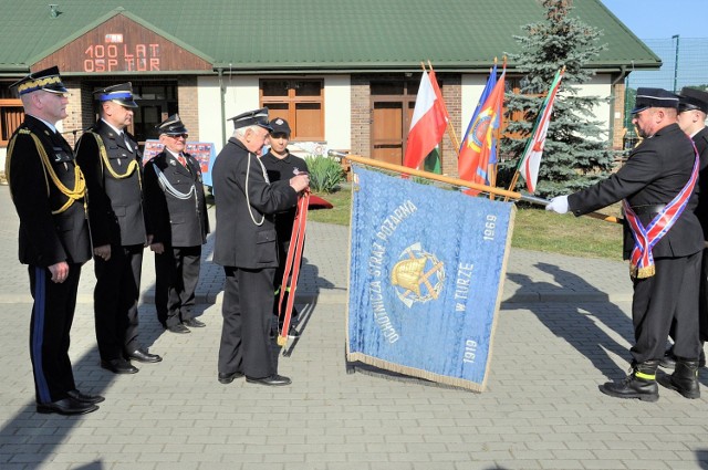 Zdzisław Dąbrowski dekoruje sztandar OSP Tur Złotym Znakiem Związku