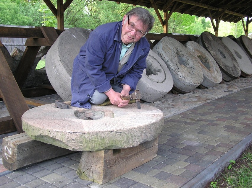 Jan Ekiel demonstruje ostrzenie kamienia młyńskiego....