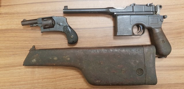 Pistolet Mauser C96 kal. 7,63 mm (z prawej). Poniżej kabura do niego, która również może służyć jako kolba. Z lewej: rewolwer Arminius Hammerless kal. 320