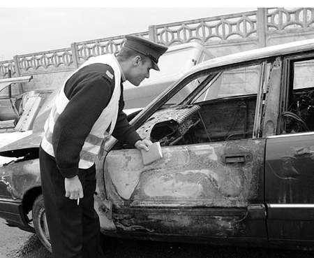 Sierżant sztabowy Sławomir Majka w czasie oględzin spalonego samochodu. Fot. Olgierd Górny
