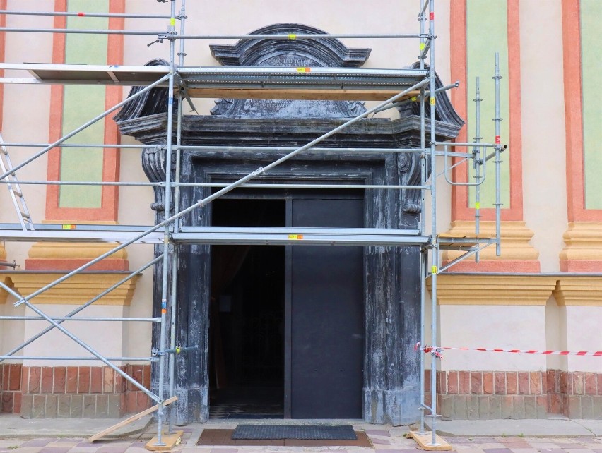 Marmurowy portal w elewacji głównej świątyni przed rozpoczęciem prac konserwatorskich. Na czas konserwacji oryginalnych XVIII-wiecznych drzwi w ościeżnicy zamontowano drzwi tymczasowe, 2022 r