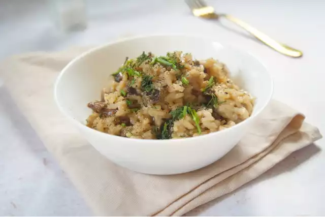 Risotto z grzybami nabiera kremowej konsystencji dzięki powolnemu gotowaniu w bulionie i zagęszczeniu masłem oraz startym parmezanem. Kliknij obrazek i przesuwaj strzałkami, aby zobaczyć etapy przygotowania.