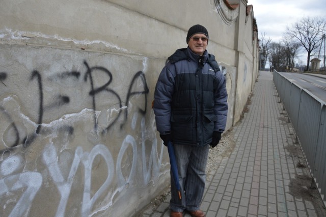 Zbigniew Kubicki jest zbulwersowany wulgarnymi napisami na murze cmentarza.