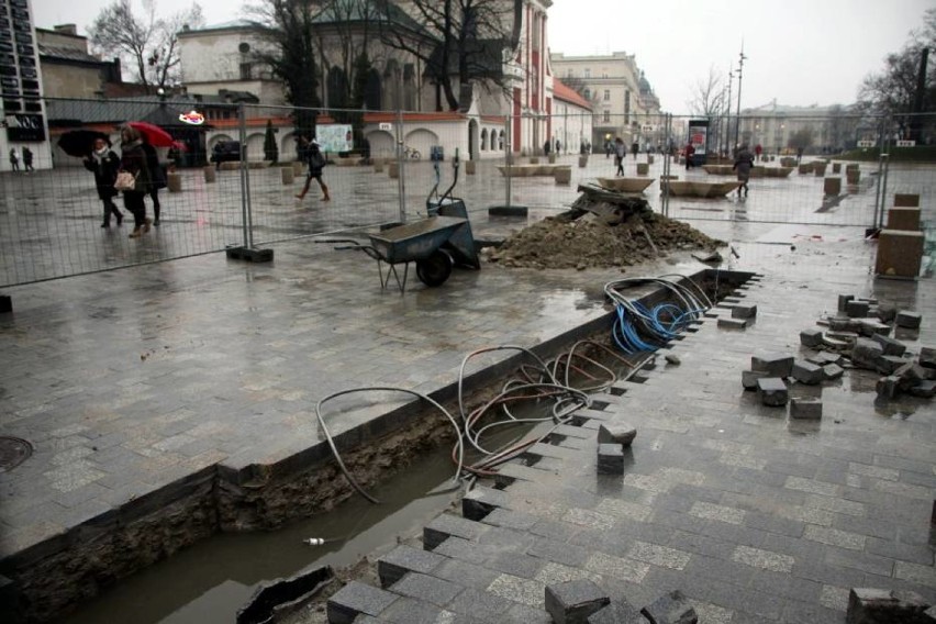 Zdjęto kostkę brukową, metalowy płot wygradza część deptaka...