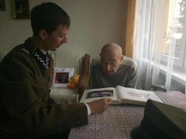 Artur Socha, członek grupy rekonstrukcyjnej Wrzesień 1939 opowiada Egeniuszowi Radomskiemu o albumie, który mu wręczono.