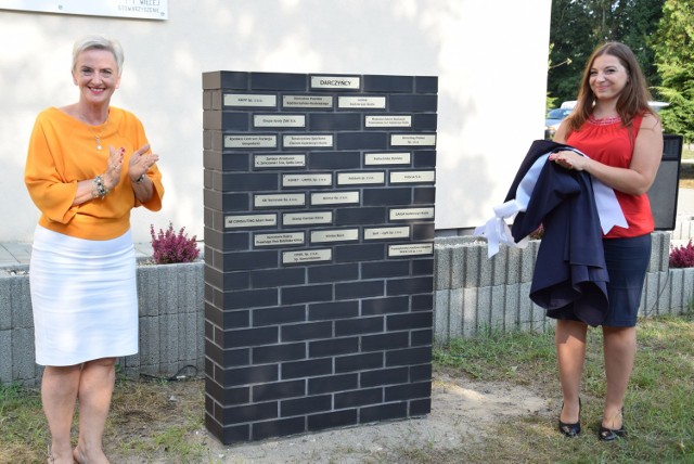 Sabina Nowosielska i Krystyna Król przy tablicy honorującej darczyńców przedszkola.
