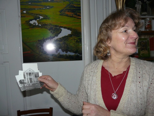 Barbara Cichecka z fotografią dworu w Zakrzewie, który znalazł się pod wodą, a w tle Warta przed budową zalewu Jeziorsko