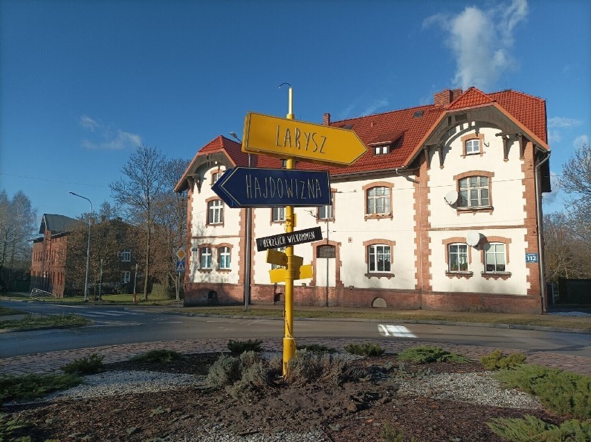 Symbol dzielnicy Larysz-Hajdowizna wzbogacony o zegar.
