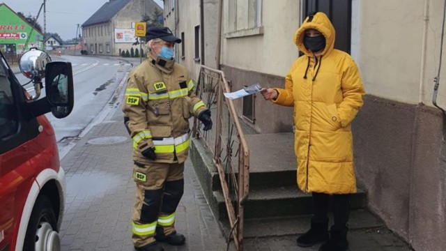 Strażacy roznoszą ulotki na temat profilaktyki oraz szczepień przeciwko COVID-19.